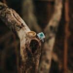 selective focus photography of gold ring and green gemstone silver ring