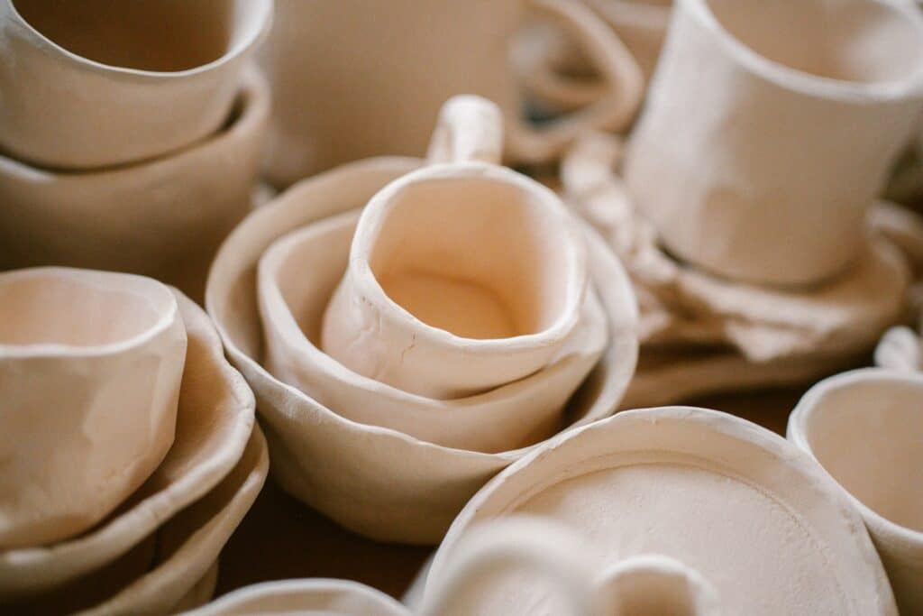 A pile of white dishes sitting on top of a table