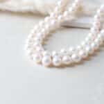 a close up of a necklace with pearls