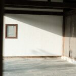 Sunlight streaming onto a white wall with a small window.