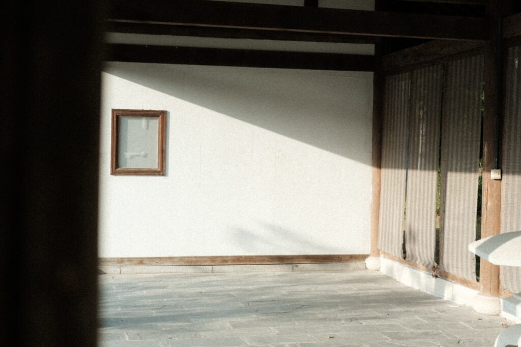 Sunlight streaming onto a white wall with a small window.