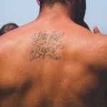 person with try fail repeat tattoo at back