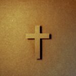 Paper cut cross laying on a paper background