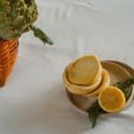 Fresh artichokes and prepared vegetables on a table.