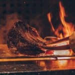 person barbecuing meat