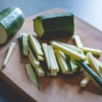 sliced green vegetable on brown wooden chopping board