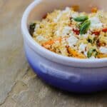 a blue bowl filled with food on top of a wooden table