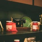 Jars of food and a sewing machine on a shelf.