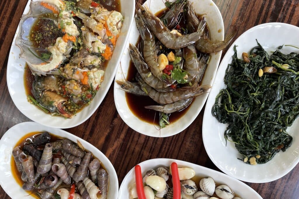 Five plates of seafood and vegetables on table