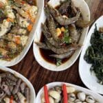 Five plates of seafood and vegetables on table