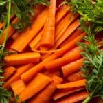 a pile of carrots and parsley on a table