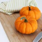 selective focus photography of two pumpkins placed on chopping board