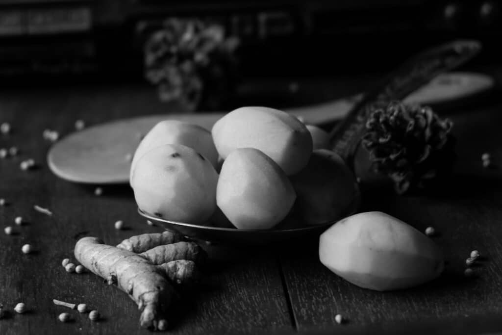 The photo is of kitchen spices in the form of potatoes, turmeric, white pepper against the background of an old radio