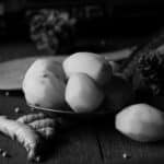 The photo is of kitchen spices in the form of potatoes, turmeric, white pepper against the background of an old radio